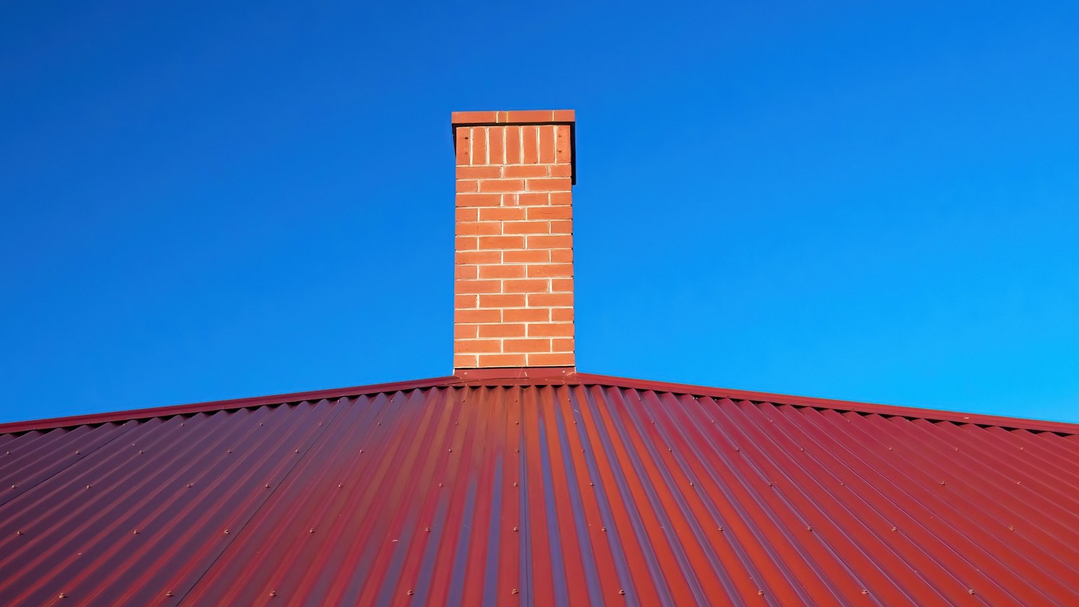 Completed metal roof with neatly finished chimney flashing