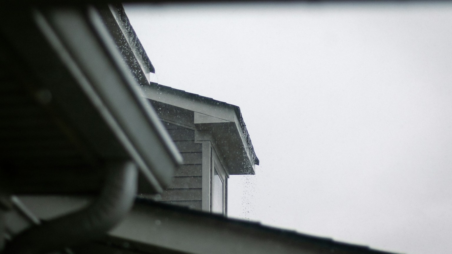 Rain running from a residential gutter during wet coastal weather