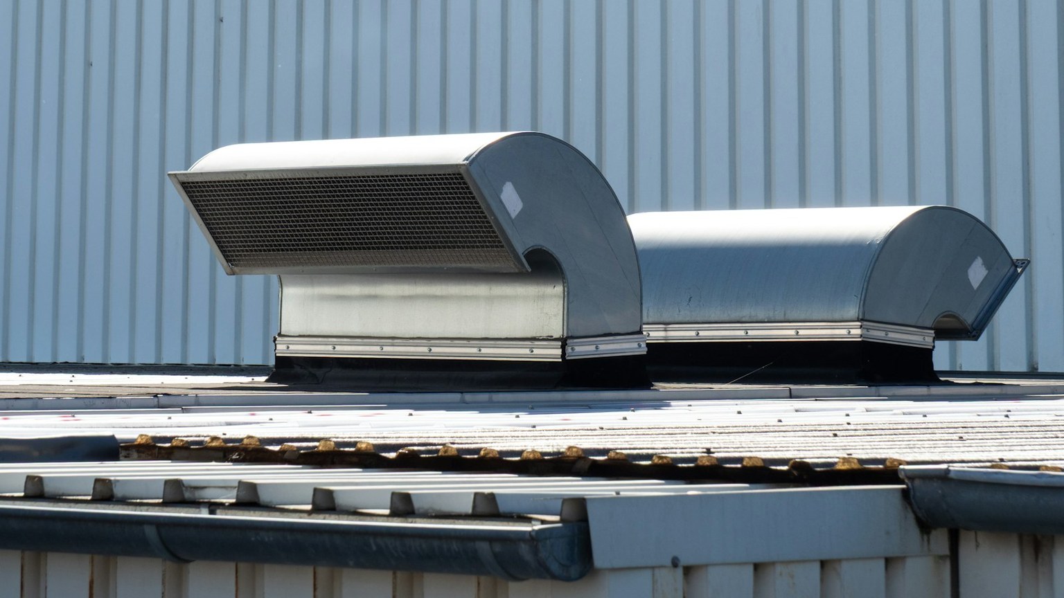 Commercial rooftop ventilation equipment and weathered metal roof seams