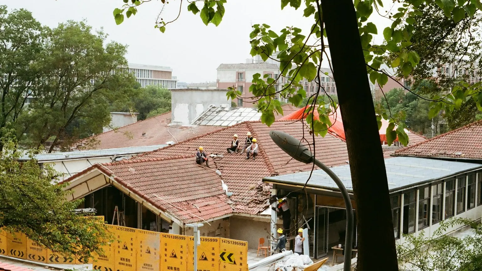 Roofing crew repairing a damaged section of an existing roof