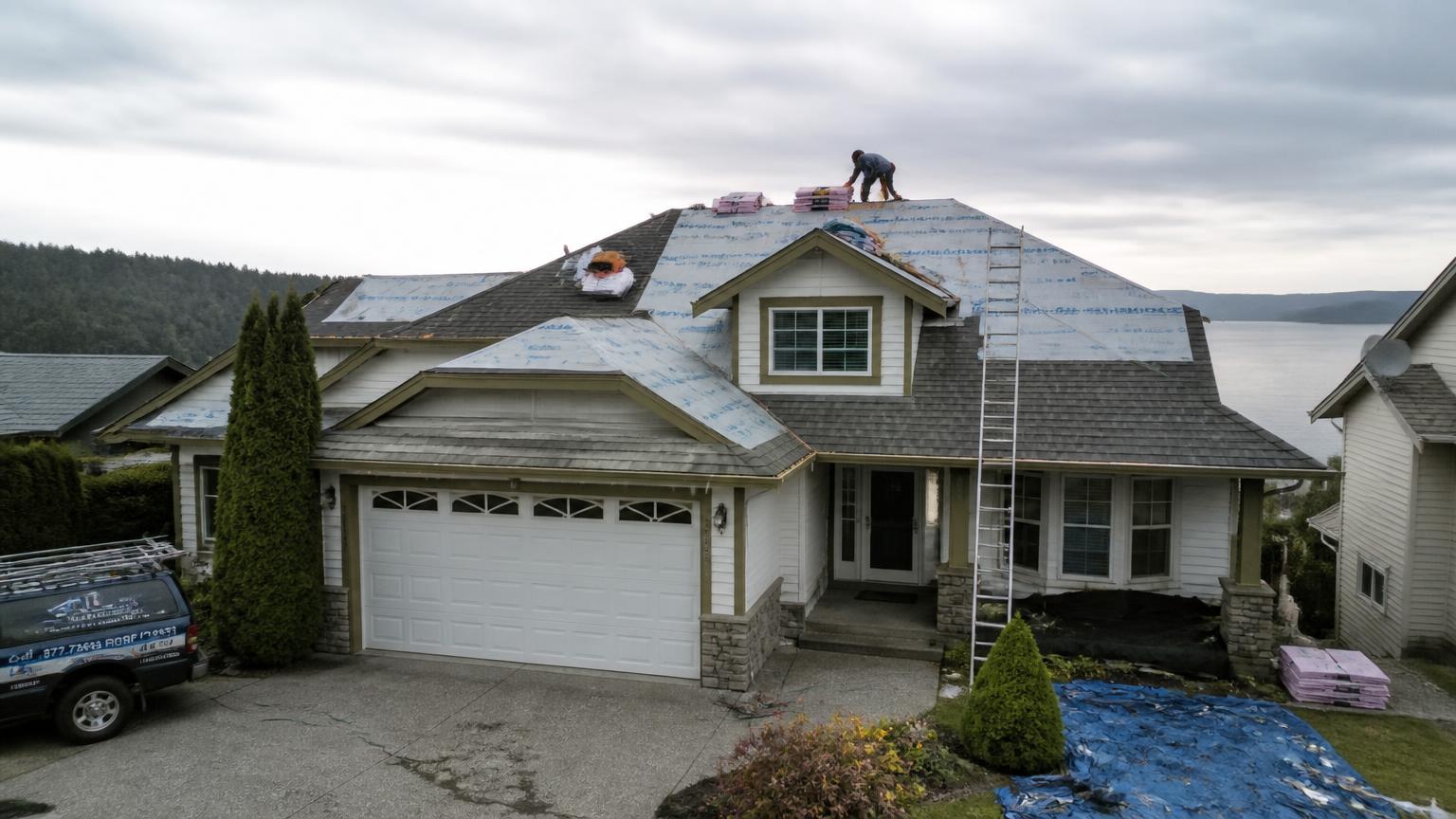 Lower Mainland home mid roof replacement with new underlayment and shingle bundles staged on the roof