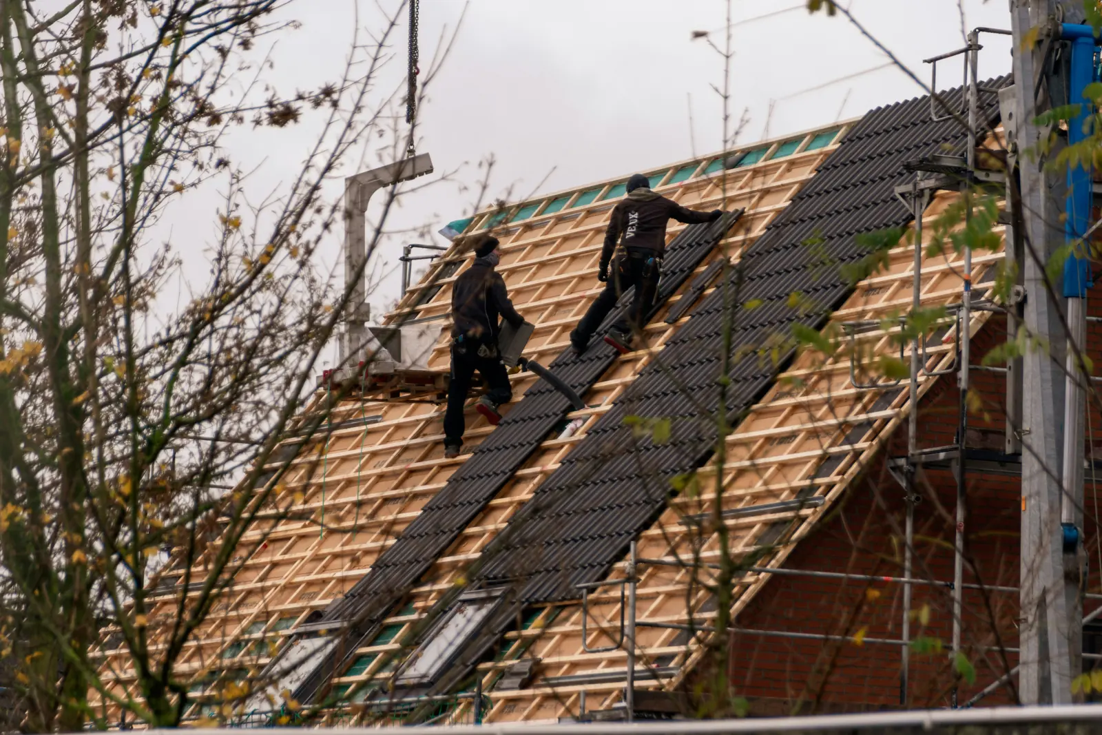 Roofers installing a new pitched roofing system on an occupied property